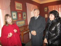 Российский космонавт и его супруга слушают рассказ директора музея