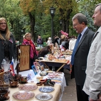 В.Филипп (слева) и В. Рыбицкий знакомятся с изделиями народных мастеров